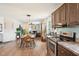 Open-concept living area showcases wood floors, a dining set with pendant lights, and a view of the kitchen at 7228 Lowery Meadow Dr, Wendell, NC 27591