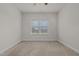 Bright bedroom with a large window and neutral-colored walls and carpeting at 8 Pal Ct, Benson, NC 27504