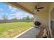 Relaxing covered patio with a seating area, barbecue grill, and view of the expansive, fenced backyard at 8 Pal Ct, Benson, NC 27504