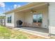 Cozy covered patio equipped with a grill, comfortable seating, and a ceiling fan for outdoor enjoyment at 8 Pal Ct, Benson, NC 27504