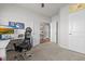This home office has gray walls, plush carpet, a functional desk setup, and an entrance with white trim at 8 Pal Ct, Benson, NC 27504