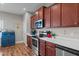 Modern kitchen featuring stainless steel appliances, quartz countertops, and cherry wood cabinets at 8 Pal Ct, Benson, NC 27504