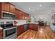 Open kitchen featuring stainless steel appliances, cherry wood cabinets, and quartz countertops at 8 Pal Ct, Benson, NC 27504
