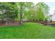 Lush, green backyard with mature trees, a wooden fence, and a large grassy area for outdoor enjoyment at 8005 Somerdale Dr, Durham, NC 27713