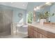 Bright bathroom featuring a soaking tub, glass enclosed shower, and double vanity with plentiful natural light at 8005 Somerdale Dr, Durham, NC 27713