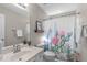 Bathroom with vanity, toilet, shower with decorative cactus-themed shower curtain, mirror, and accent shelving at 8005 Somerdale Dr, Durham, NC 27713