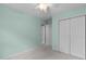 Bright bedroom with closet, neutral carpet, ceiling fan with light, and backyard views at 8005 Somerdale Dr, Durham, NC 27713