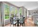 Dining area with a glass table and chairs next to windows and open to living area at 8005 Somerdale Dr, Durham, NC 27713