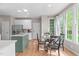 Bright dining area with a glass table, modern chairs, and large windows with backyard views at 8005 Somerdale Dr, Durham, NC 27713