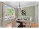 Dining room with large window, green walls, hardwood floors, wainscoting, and table set for four at 8005 Somerdale Dr, Durham, NC 27713