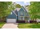 Charming two-story home with a well-manicured lawn, blue siding, and an attached two-car garage at 8005 Somerdale Dr, Durham, NC 27713