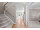 Welcoming foyer with hardwood floors, carpeted staircase, and open view to the living room and front door at 8005 Somerdale Dr, Durham, NC 27713