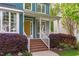Inviting front porch with brick steps, white railings, and a bright yellow front door at 8005 Somerdale Dr, Durham, NC 27713