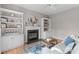 Inviting living room featuring a fireplace with built-in bookshelves and hardwood floors at 8005 Somerdale Dr, Durham, NC 27713