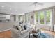 Bright living room with hardwood floors, neutral walls, large windows, and a comfortable couch with decorative pillows at 8005 Somerdale Dr, Durham, NC 27713