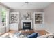 Comfortable living room with fireplace, built-in shelving, and a ceiling fan at 8005 Somerdale Dr, Durham, NC 27713
