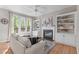 Cozy living room with a fireplace, built-in bookshelves, and plenty of natural light at 8005 Somerdale Dr, Durham, NC 27713