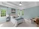 Main bedroom with tray ceilings, blue walls, carpet, a queen bed and two windows for natural light at 8005 Somerdale Dr, Durham, NC 27713