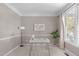 Home office with large windows, white desk, a neutral carpet, and a decorative world map on the wall at 8005 Somerdale Dr, Durham, NC 27713