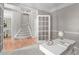 Bright home office with modern white desk, gray walls, and open doorway leading to the carpeted stairs at 8005 Somerdale Dr, Durham, NC 27713