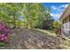 Well-manicured backyard with flourishing greenery, wood deck, and privacy landscaping at 8022 Hogan Dr, Wake Forest, NC 27587