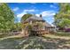 Large brick home featuring a multi-tiered wood deck and lush landscaping in backyard at 8022 Hogan Dr, Wake Forest, NC 27587