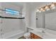 Bright bathroom featuring a tub with shower, white tile, modern lighting, and stylish vanity at 8022 Hogan Dr, Wake Forest, NC 27587