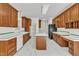Traditional kitchen featuring white marble floors, wood cabinets, an island cooktop, and sleek appliances at 8022 Hogan Dr, Wake Forest, NC 27587