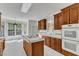 View of kitchen with wood cabinetry, tiled countertops and backsplash, stainless appliances, and eat-in nook at 8022 Hogan Dr, Wake Forest, NC 27587