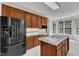 View of kitchen with wood cabinetry, tiled countertops and backsplash, stainless appliances, and eat-in nook at 8022 Hogan Dr, Wake Forest, NC 27587