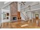 Bright living room with a brick fireplace, staircase, hardwood floors, and seamless flow to adjoining spaces at 8022 Hogan Dr, Wake Forest, NC 27587