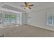 Large living room featuring neutral carpet, a ceiling fan, and natural light from multiple windows at 8022 Hogan Dr, Wake Forest, NC 27587