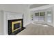 Bright living room featuring neutral carpet, a fireplace, and multiple windows with outdoor views at 8022 Hogan Dr, Wake Forest, NC 27587