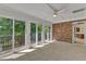 Bright sunroom featuring sliding glass doors leading to a deck and a charming brick accent wall at 8022 Hogan Dr, Wake Forest, NC 27587