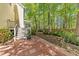 Backyard with stairs leading to a deck, surrounded by lush greenery and mature trees, and a patio at 8212 Duck Creek Dr, Raleigh, NC 27616