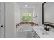 Relaxing bathroom features a large tub, patterned tile surround, and ample natural light at 8212 Duck Creek Dr, Raleigh, NC 27616