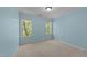 The bedroom has light-blue painted walls, neutral carpet, crown molding, and two windows overlooking trees at 8212 Duck Creek Dr, Raleigh, NC 27616
