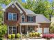 Charming two-story brick home features manicured landscaping, a front porch, and an attached two-car garage at 8212 Duck Creek Dr, Raleigh, NC 27616