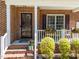 Inviting front porch with brick steps, white railings, and decorative hanging flower baskets at 8212 Duck Creek Dr, Raleigh, NC 27616