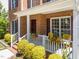 Charming front porch with decorative yellow chairs, hanging plants, and well-kept landscaping at 8212 Duck Creek Dr, Raleigh, NC 27616