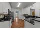 An inviting kitchen featuring stainless appliances, white cabinetry, and hardwood floors at 8212 Duck Creek Dr, Raleigh, NC 27616