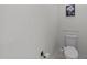 Clean toilet room with modern toilet, neutral wall, and bronze fixtures at 8212 Duck Creek Dr, Raleigh, NC 27616