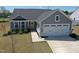 Charming single-Gathering home with a two-car garage, gray siding, and a welcoming front door at 8764 Kenridge Ln, Fuquay Varina, NC 27526