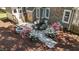 Aerial view of the backyard featuring a stone patio, outdoor seating, a firepit and lush flowering shrubs at 903 Oldwyck Dr, Fuquay Varina, NC 27526