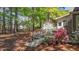 Beautiful backyard with a stone walkway, lush flowering shrubs, and a glimpse of the outbuildings at 903 Oldwyck Dr, Fuquay Varina, NC 27526