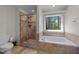 Bathroom featuring a tiled shower and a soaking tub beneath a window at 903 Oldwyck Dr, Fuquay Varina, NC 27526