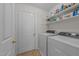 Functional laundry room with washer, dryer, and shelving for storage at 903 Oldwyck Dr, Fuquay Varina, NC 27526