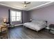 Large bedroom with a tray ceiling, natural light, and dark hardwood floors at 937 Matterhorn Dr, Fuquay Varina, NC 27526