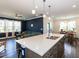 Bright kitchen with a large island, modern lighting, stainless steel appliances, and an open view into the living room at 937 Matterhorn Dr, Fuquay Varina, NC 27526