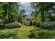 A lush backyard with mature landscaping and charming exterior with deck at 959 Sagamore Dr, Louisburg, NC 27549